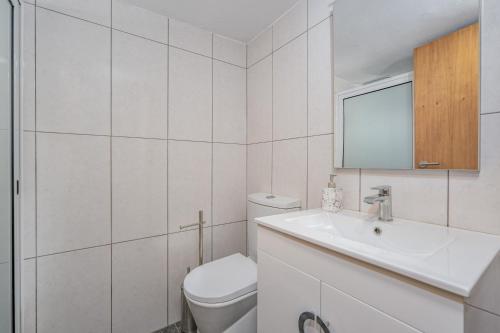 ein weißes Bad mit einem WC und einem Waschbecken in der Unterkunft Casa da Quebrada in Santana