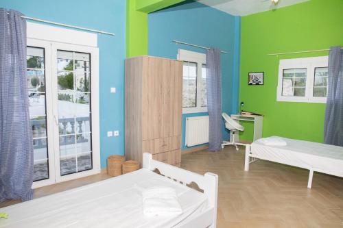 um quarto com duas camas e paredes verdes e azuis em Emerald Heaven em Panteli
