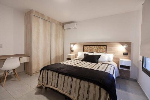 a bedroom with a large bed and a chair at Casa Wineland Logde West 4Pax - by Inside in Ciudad Lujan de Cuyo
