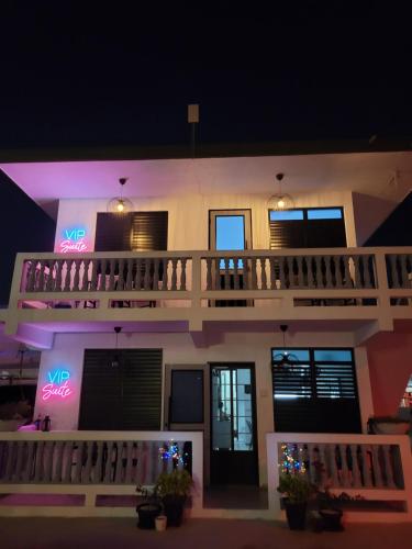 a building with neon signs on it at night at Luichy's Seaside Hotel at Playa El Combate in El Combate