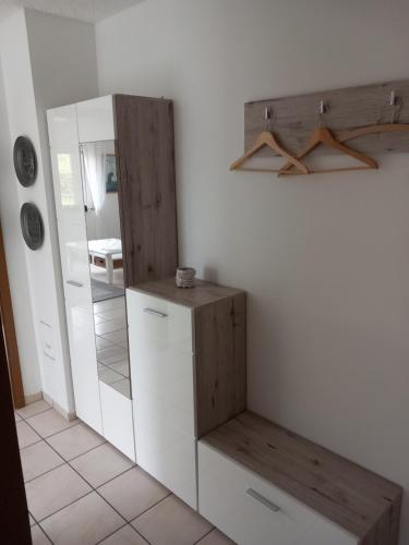 a kitchen with white cabinets and a mirror at Widmann‘s Ferienquartier in Wiehl