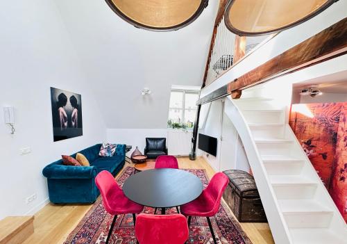 a living room with a table and red chairs at Gilly's Gallery in Breda