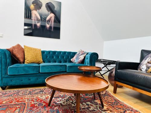 ein Wohnzimmer mit einem blauen Sofa und einem Tisch in der Unterkunft Gilly's Gallery in Breda