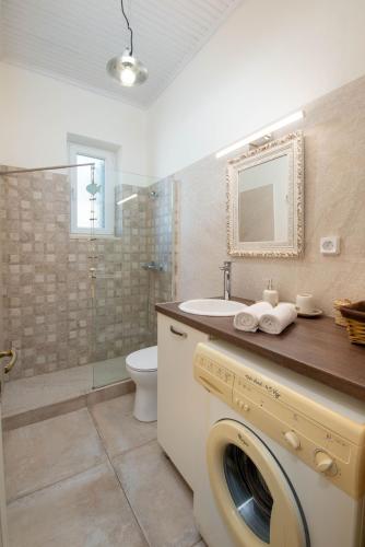 a bathroom with a washing machine and a sink at Villa Labovitsa in Vlachopoulátika