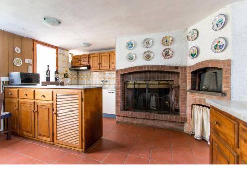 a kitchen with a fireplace with plates on the wall at Villa del Monte di Cocco in Massarosa