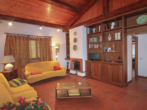 uma sala de estar com um sofá amarelo e uma televisão em Villa del Monte di Cocco em Lucca