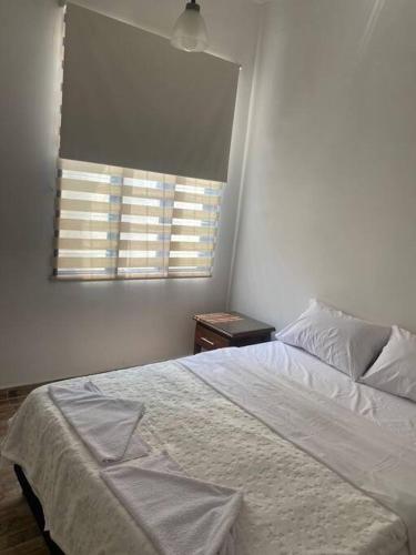 a bedroom with a white bed and a window at Casa Aparicio in Buga