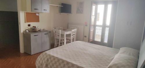 Cet appartement comprend une chambre avec un lit et une cuisine avec une table. dans l'établissement B&B Ninfa, à Caserte