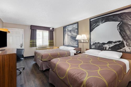 a hotel room with two beds and a flat screen tv at Super 8 by Wyndham Richfield UT in Richfield