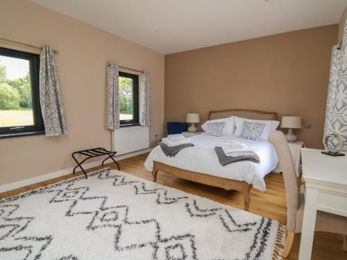 ein Schlafzimmer mit einem Bett und einem Tisch und Fenstern in der Unterkunft Heritage in Carmarthen