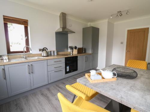 a kitchen with a table and yellow chairs at Sea View in Carmarthen