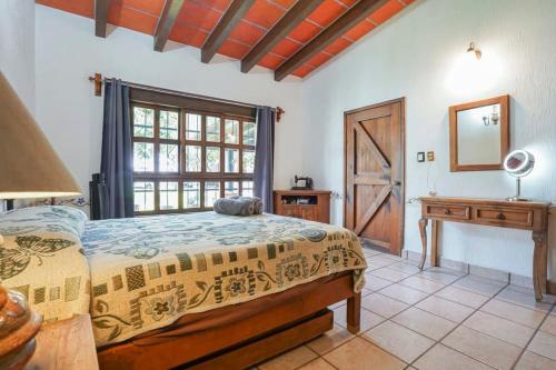 奧克斯特派克的住宿－Amazing family house in Oaxtepec Pool & Hot tub，一间卧室配有一张床、一张书桌和一个窗户。