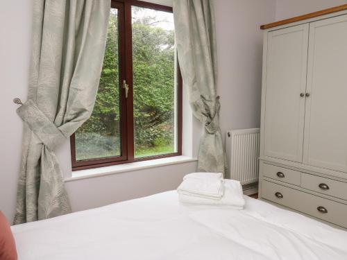 a bedroom with a bed and a window at The Oaks in Carmarthen