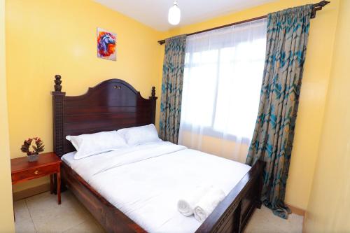 a bedroom with a large bed and a window at The Perfect New Nest in Nairobi