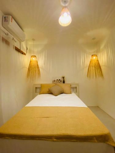 1 dormitorio con 1 cama grande y 2 luces en Vila Oceano en Barra de São Miguel