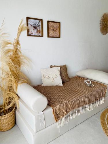 un sofá blanco en una habitación con dos cuadros en la pared en Vila Oceano en Barra de São Miguel