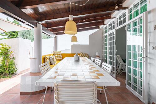 une salle à manger extérieure avec une table et des chaises blanches dans l'établissement Villa Tiffany T58 by Rentbeat, à Rosa Marina