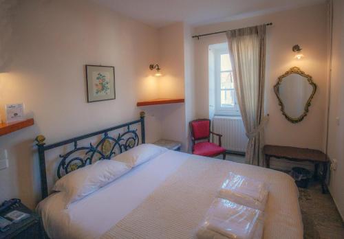 a bedroom with a bed and a mirror and a window at Byron Hotel in Nafplio