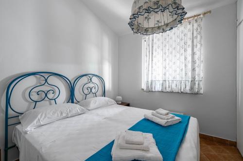 Un dormitorio con una cama azul y blanca con toallas. en Villa Tiffany T58 by Rentbeat, en Rosa Marina