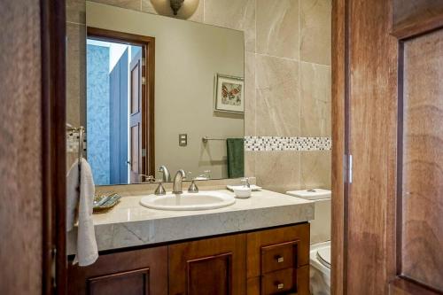 een badkamer met een wastafel en een spiegel bij Lujoso departamento en Leon in León