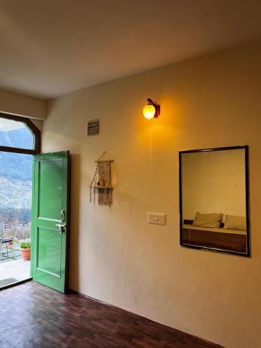 a mirror on a wall in a room with a door at Devcasa By Nomadic Den Manali in Manāli
