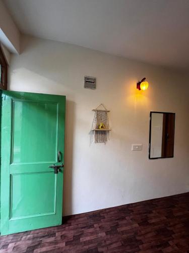 a room with a green door and a mirror at Devcasa By Nomadic Den Manali in Manāli