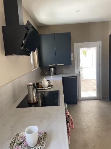 - une cuisine avec des armoires noires et un bol blanc sur un comptoir dans l'établissement Maison de ville Logement entier, à Avignon