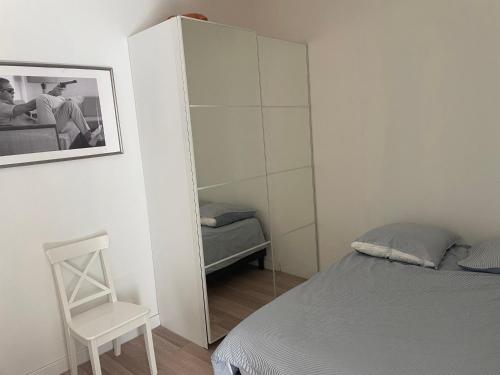 une chambre avec un lit, une chaise et un miroir dans l'établissement Maison de ville Logement entier, à Avignon