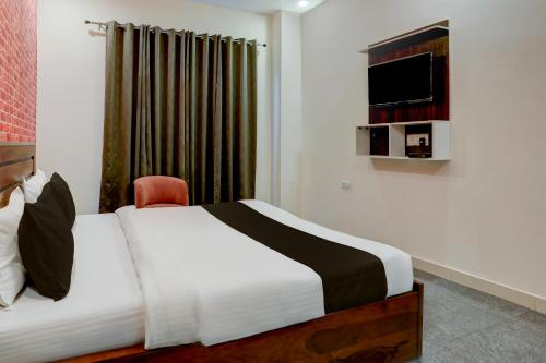 ein Hotelzimmer mit einem Bett und einem TV in der Unterkunft HOTEL AASTHA SHREE DHAM in Lucknow