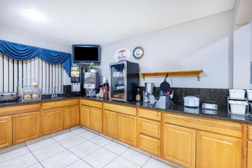 a kitchen with wooden cabinets and a counter top at Super 8 by Wyndham Richfield UT in Richfield