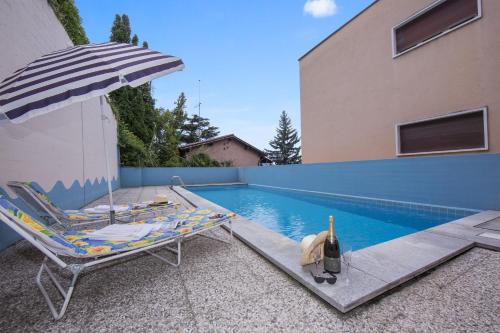 uma cadeira e um guarda-sol junto a uma piscina em Aldesago Panoramica em Aldesago