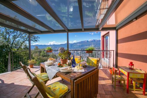 einen Wintergarten mit einem Tisch und Stühlen auf einer Terrasse in der Unterkunft Viganello Panoramica in Viganello