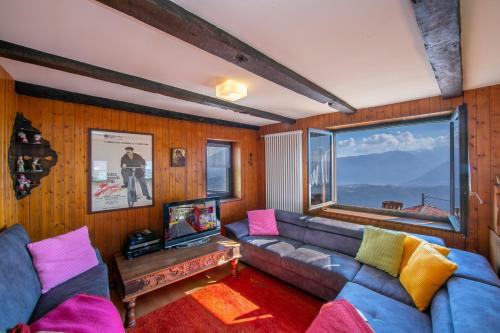a living room with a couch and a large window at Chalet Cademario - Happy Rentals in Cademario
