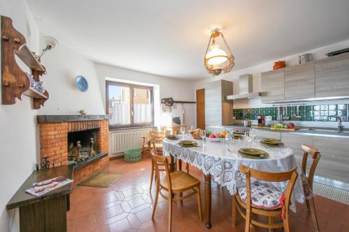 a kitchen with a table with chairs and a fireplace at Chalet Cademario - Happy Rentals in Cademario