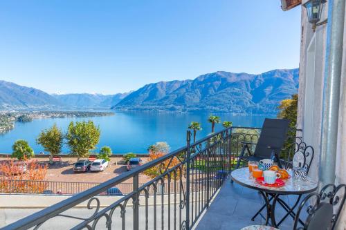 d'un balcon avec une table et une vue sur le lac. dans l'établissement Yellow View Apartment - Happy Rentals, à Ronco sopra Ascona