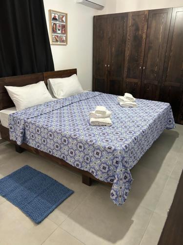 Studio flat 7A في Hamrun: غرفة نوم بسرير وبطانية زرقاء وبيضاء
