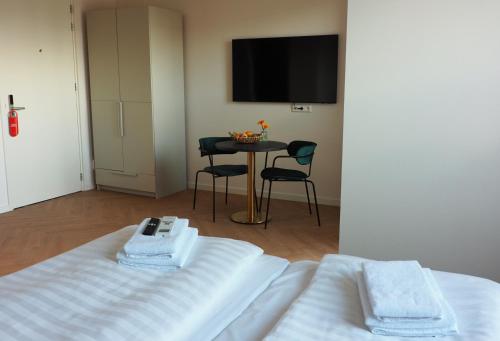 Zimmer mit einem Bett und einem Tisch mit einem TV in der Unterkunft Hotel 't Vertrek in Boxmeer