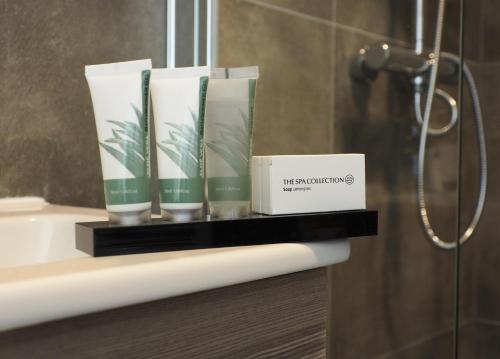 a shelf in a bathroom with three books on it at Hotel 't Vertrek in Boxmeer