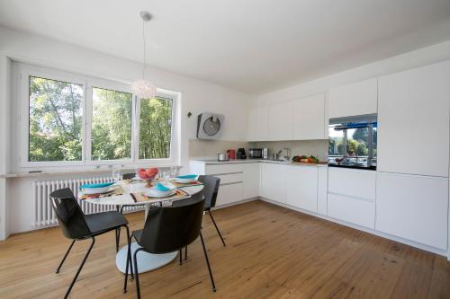 a kitchen with white cabinets and a table and chairs at Charm Apartment - Happy Rentals in Ascona