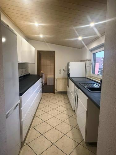 a kitchen with white cabinets and a tile floor at L8 Street-Ketsch in Ketsch