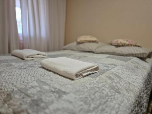 two white towels sitting on top of a bed at Apartament Zającówka - centrum miasta w leśnej enklawie in Szklarska Poręba