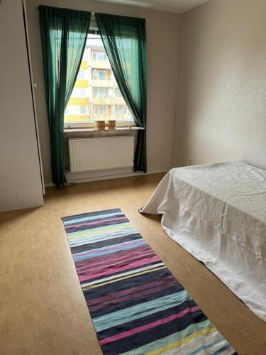 a bedroom with a bed and a large window at 2 sovrum i en del av lägenheten in Stockholm