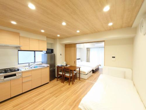 a kitchen and living room with a bed and a table at Mezon Akihabara Guest House in Tokyo