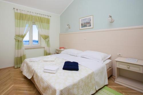 a bedroom with a bed with two towels on it at Luxury Panorama Villa Dia in Brsečine