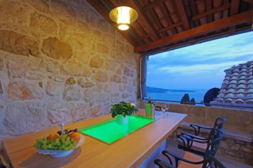 a dining room with a table and a large window at Luxury Panorama Villa Dia in Brsečine