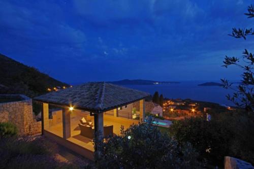 a house with a gazebo at night at Luxury Panorama Villa Dia in Brsečine