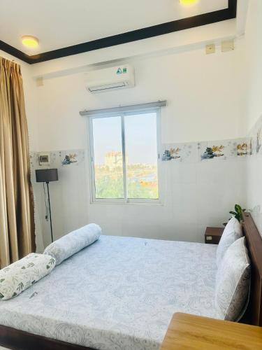 a bedroom with a large bed with a window at KimMy Home in Phan Thiet