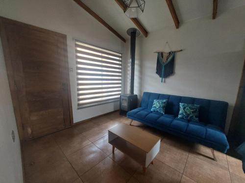 艾森港的住宿－Mi Cabaña，客厅配有蓝色的沙发和桌子