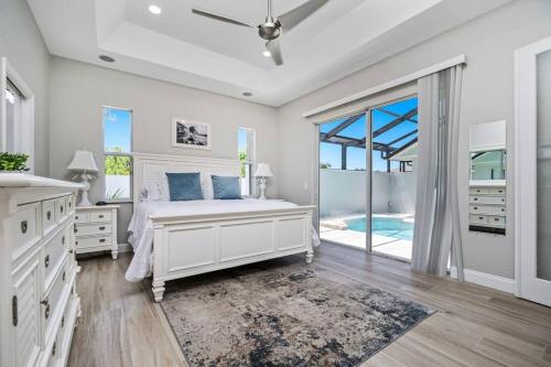 - une chambre blanche avec un lit et une grande fenêtre dans l'établissement Newly Remodeled 4BR/3BA, Private Pool, Sleeps 8, à Port Charlotte