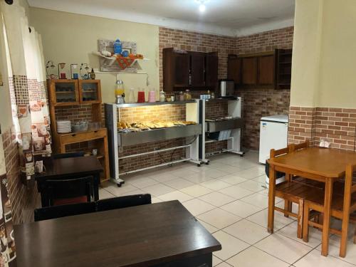 a kitchen with a table and a counter in a room at Pousadaa São João 144 in Aparecida